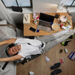 young-man-getting relaxed after working and sitting and yawning while sitting at laptop