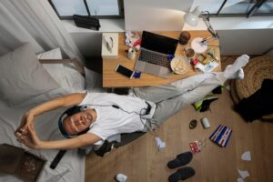 young-man-getting relaxed after working and sitting and yawning while sitting at laptop